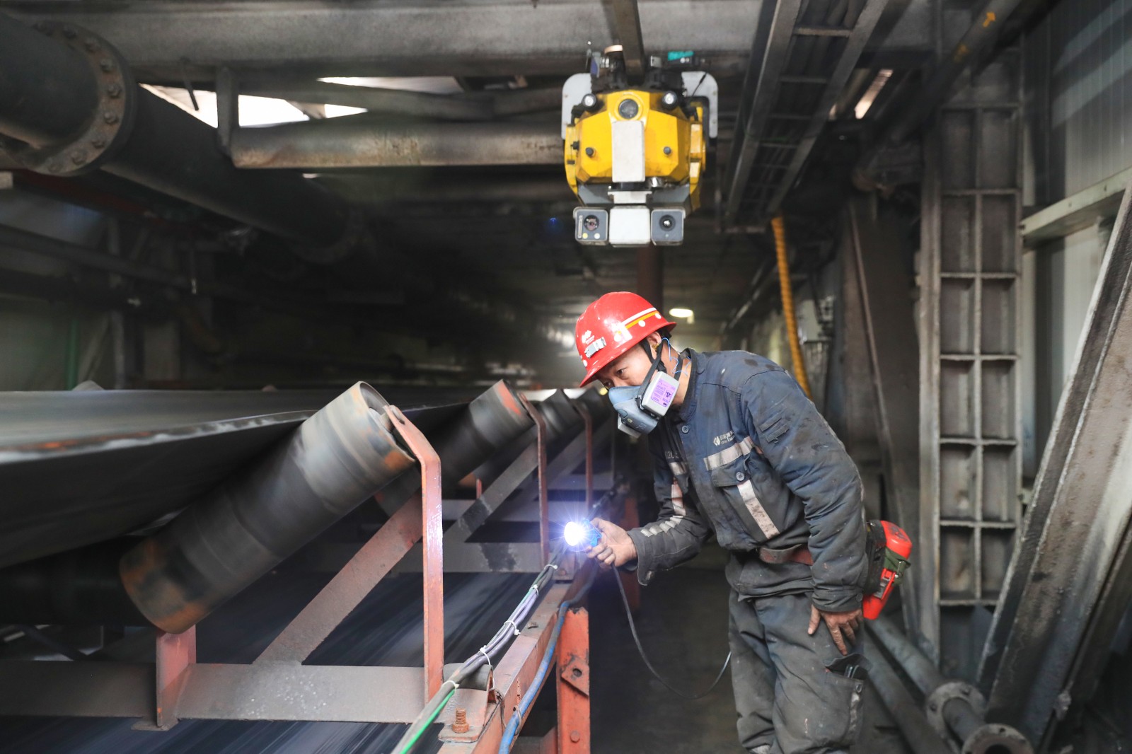 圖為李海軍正在根據(jù)托輥監(jiān)測機器人的預(yù)警檢查托輥